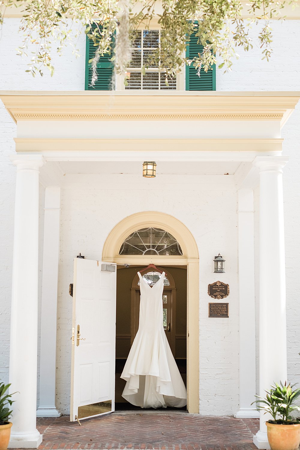 White satin dress hangs in the doorway of the historic Ribault Club