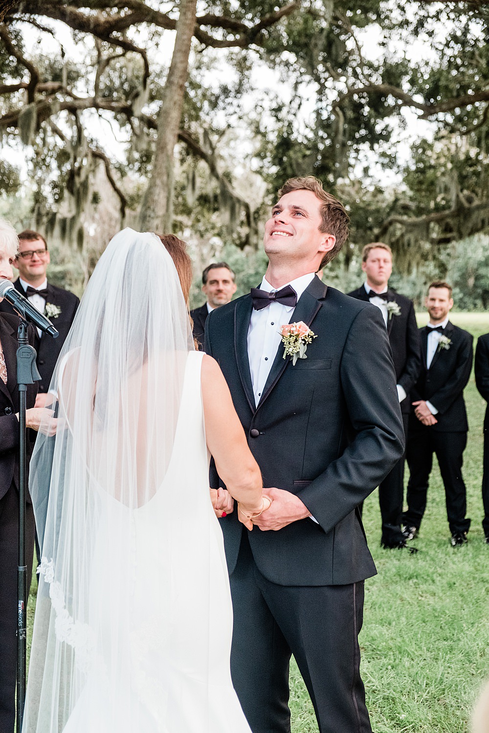Groom holds back tears while giving his vows to bride at wedding ceremony