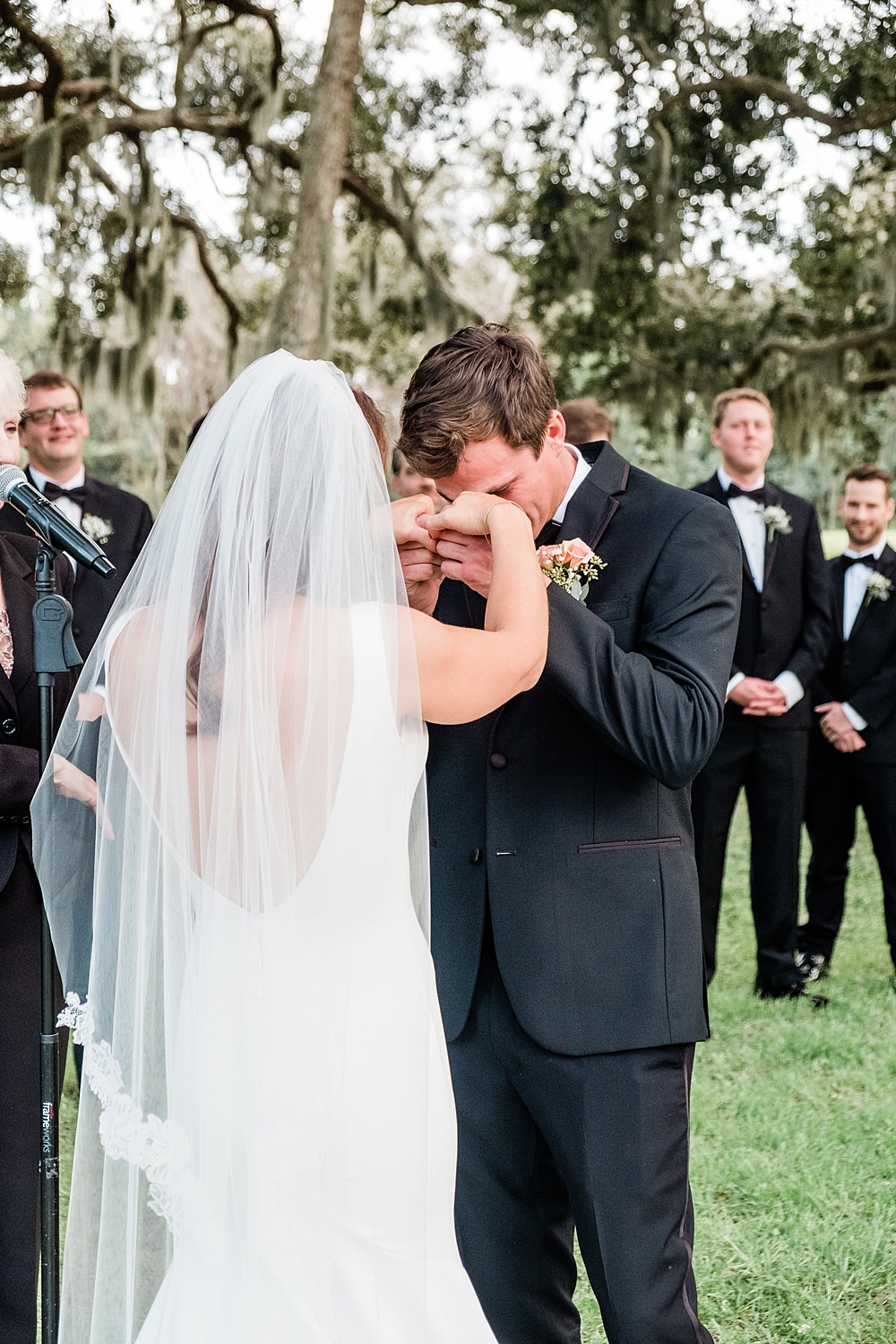 groom wipes away tears during his wedding ceremony at the ribault club