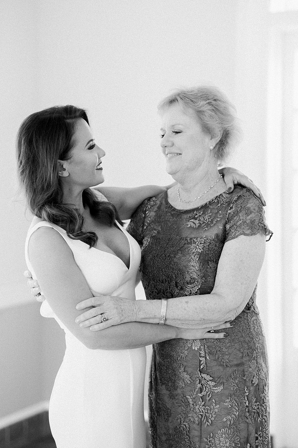 Black and white image of bride and her mom hugging