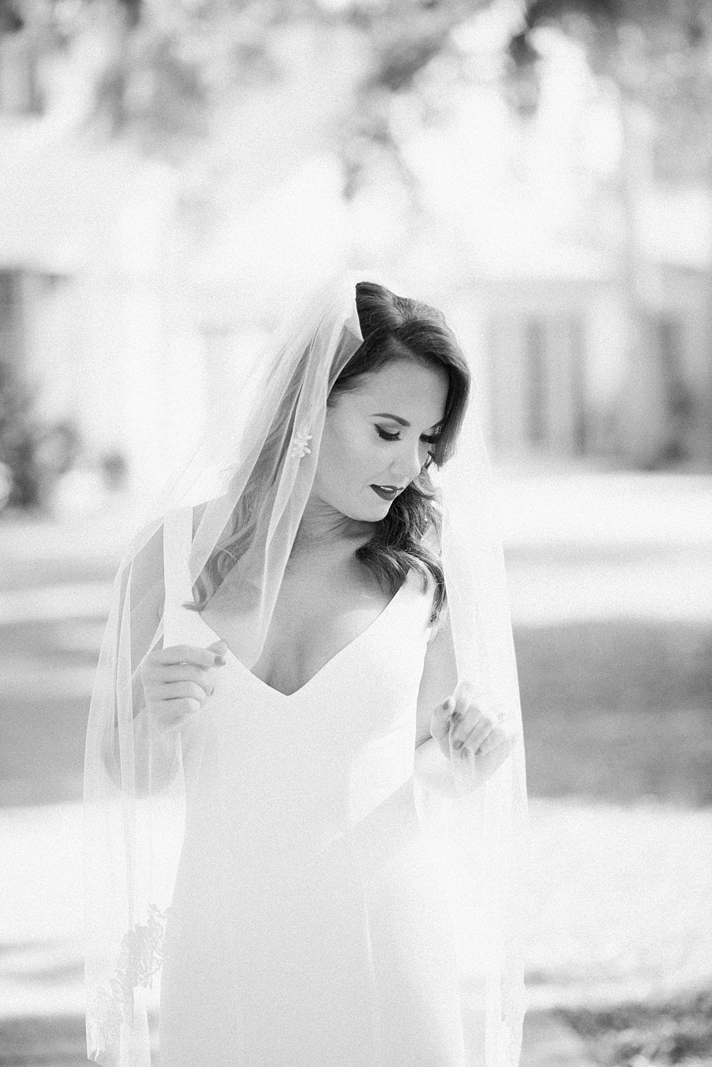 intimate Black and white image of bride holding onto her veil