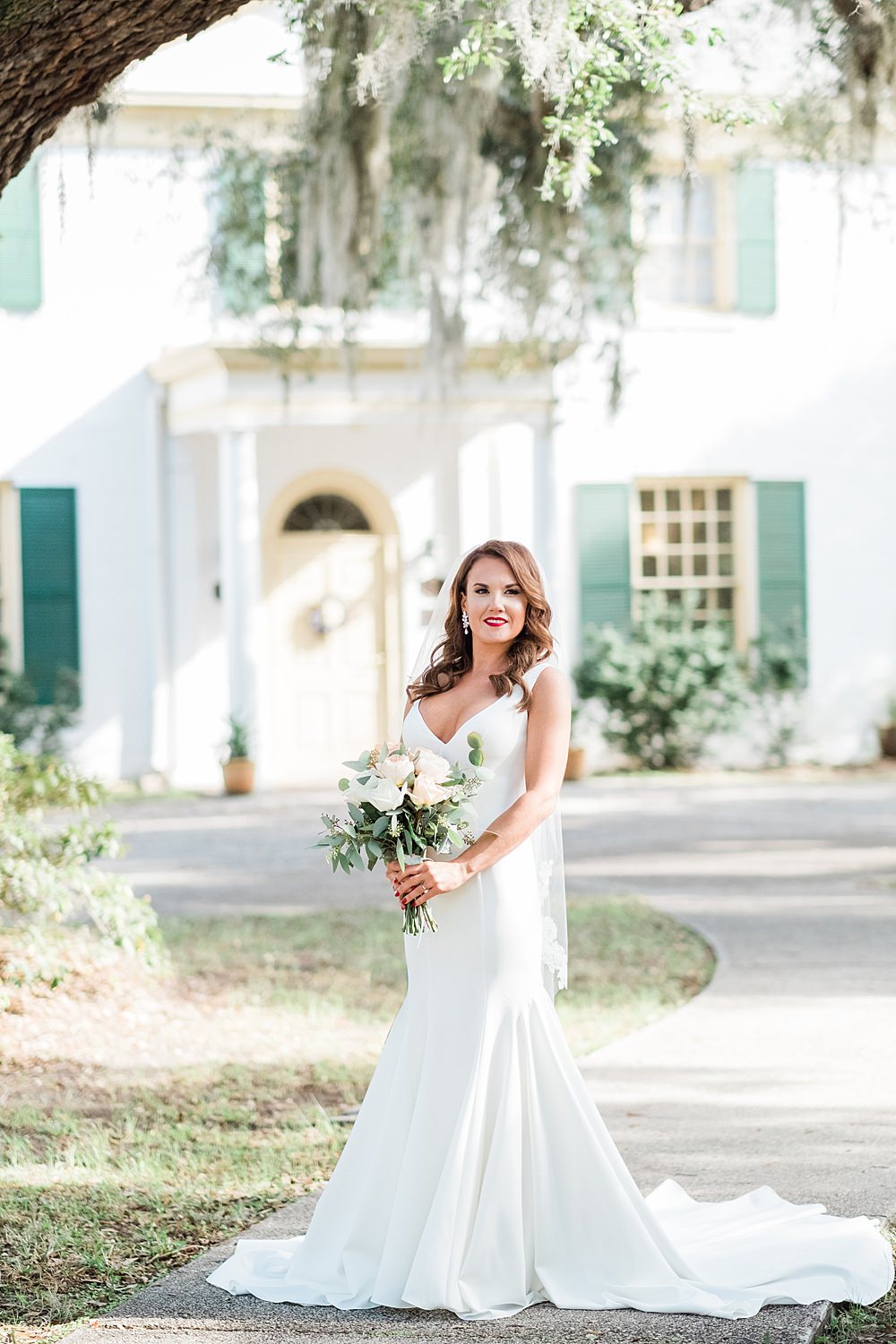 Bride stands in wedding dress outside of the historic ribault club in jacksonville, fl