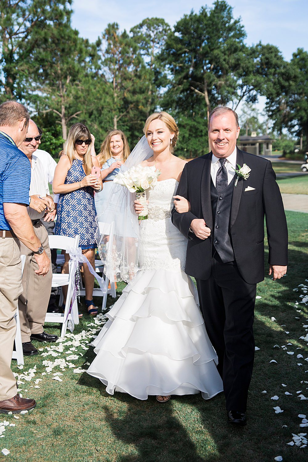 Bride and dad are all smiles as they walk down the ceremony aisle