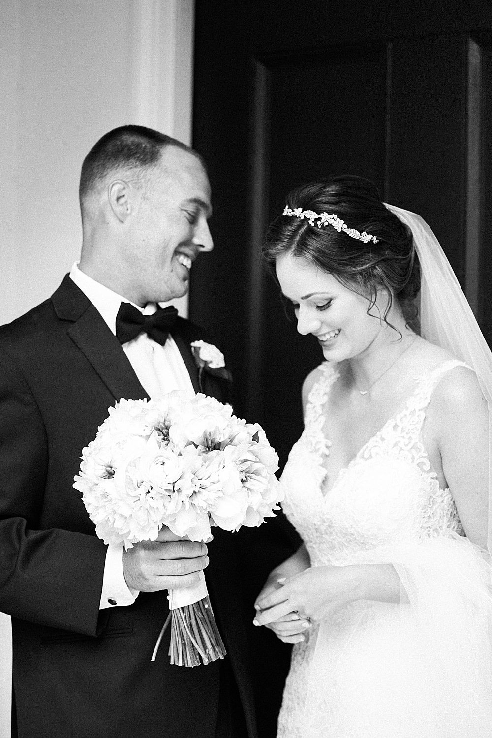 Black and white image of bride and groom laughing after their wedding ceremony