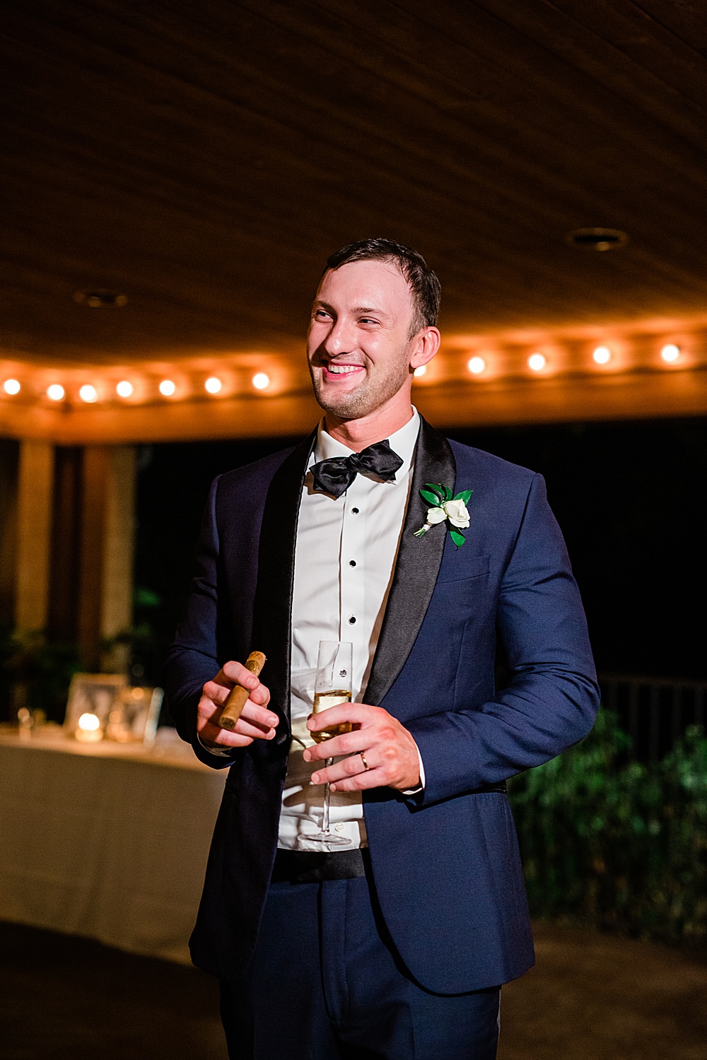 Portrait of a groom holding a glass of champagne and cigar