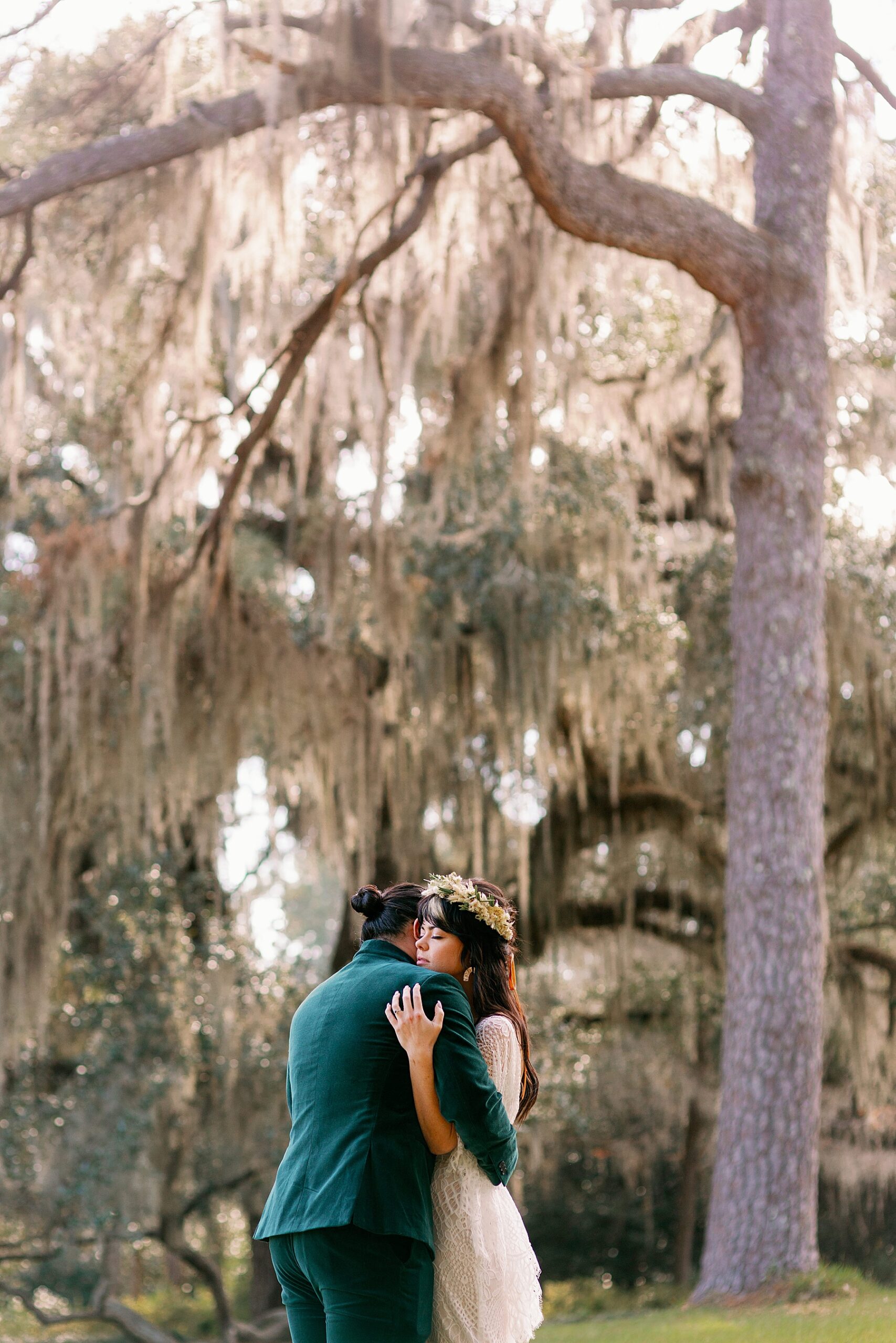 Bride and Groom share an intimate hug underneath sun soaked trees