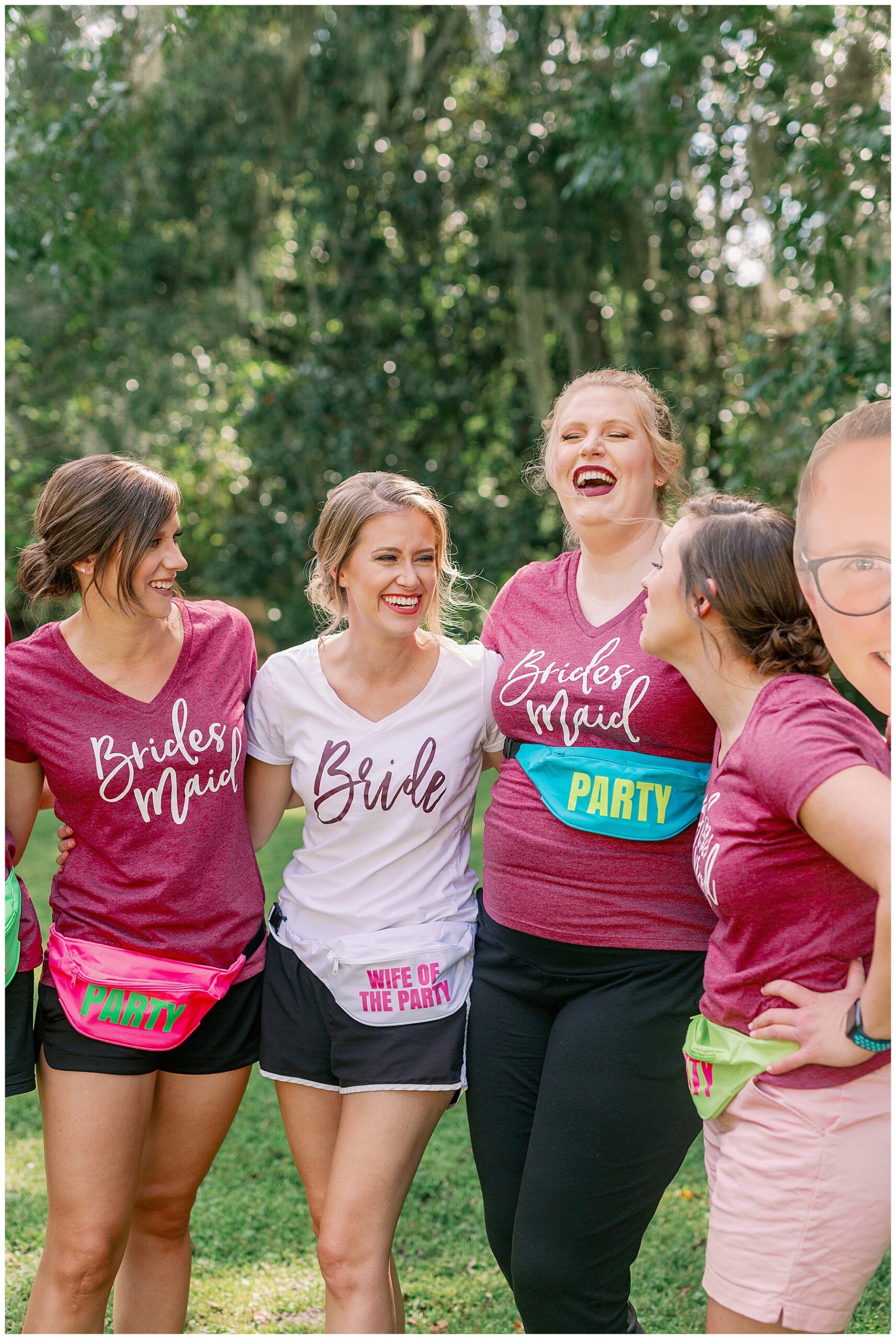 Bride and bridesmaids laughing in their matching tshirts and fanny packs